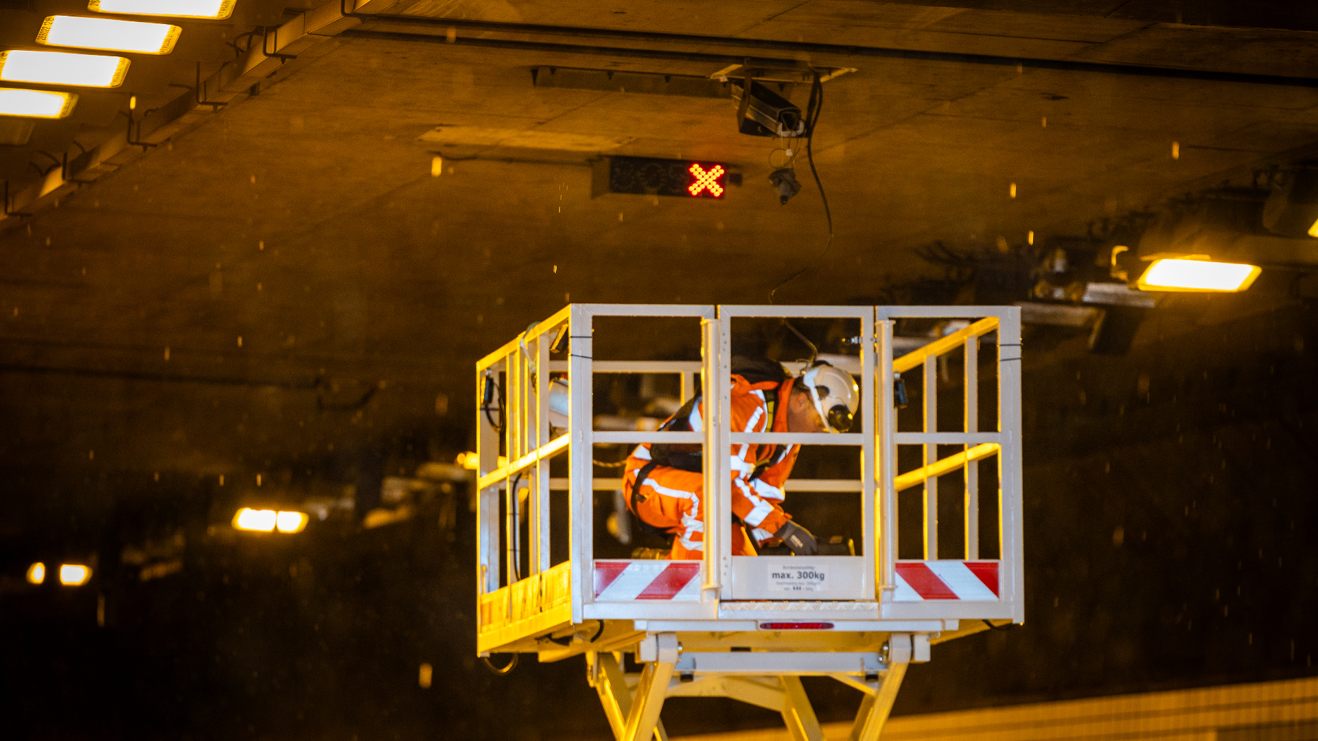 In de Thomassentunnel is een monteur bezig om een kapotgereden camera te repareren