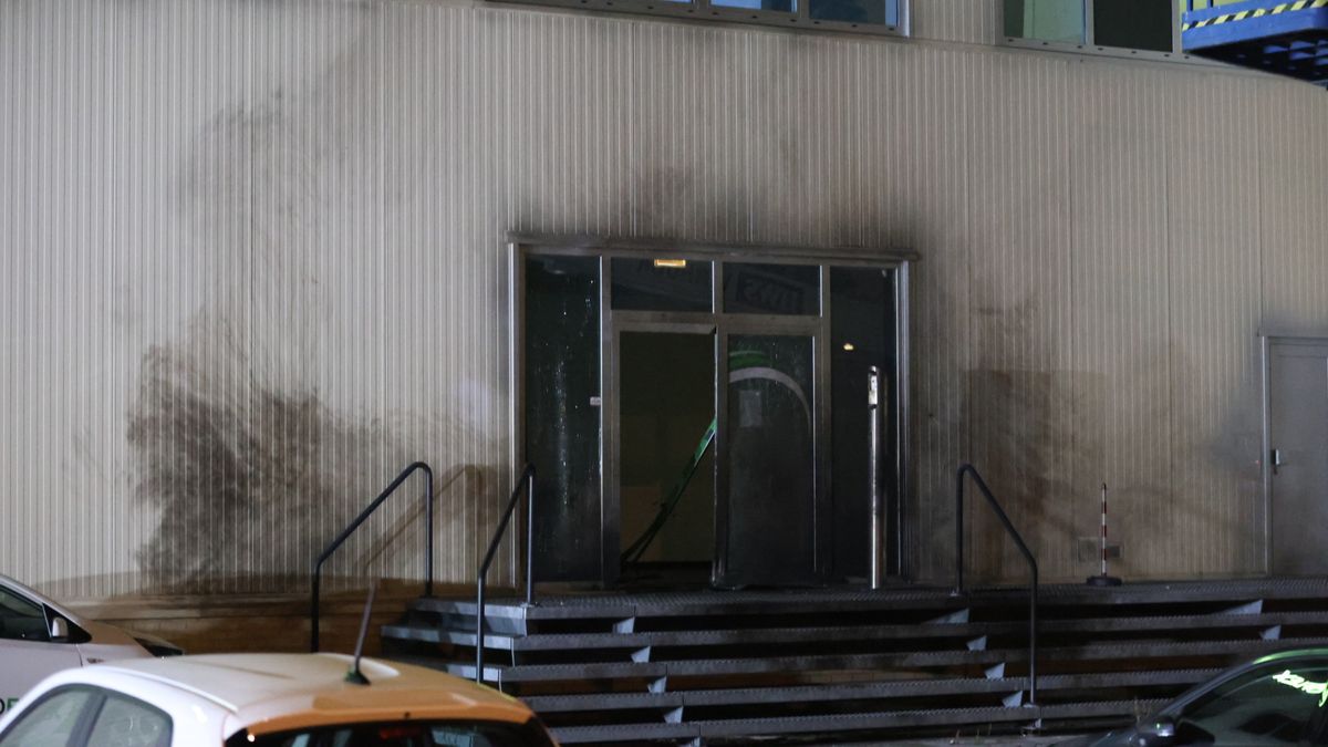 Explosie bij bedrijfspand, deur vliegt uit gevel