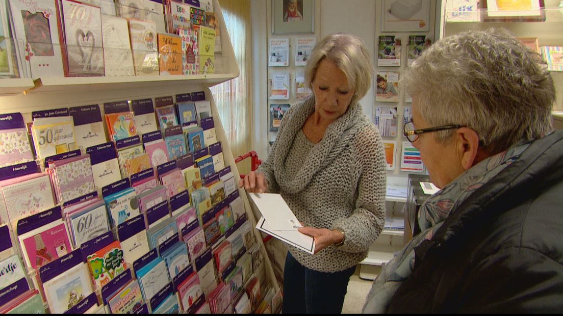 Hanny Nijssen helpt een klant met het uitzoeken van een kaartje