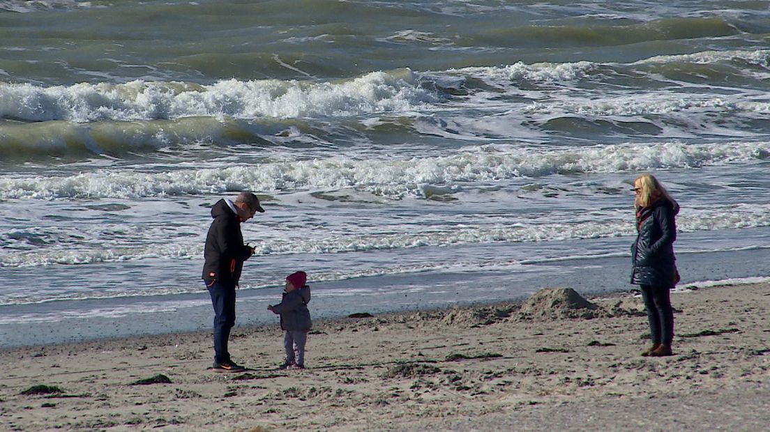 Familie aan de wandel op het strand in Burgh-Haamstede