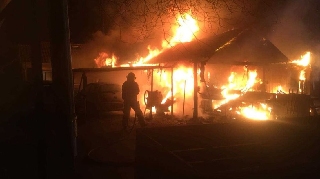 Een forse uitslaande brand heeft woensdag een grote schuur naast een houten huis in Epe verwoest.