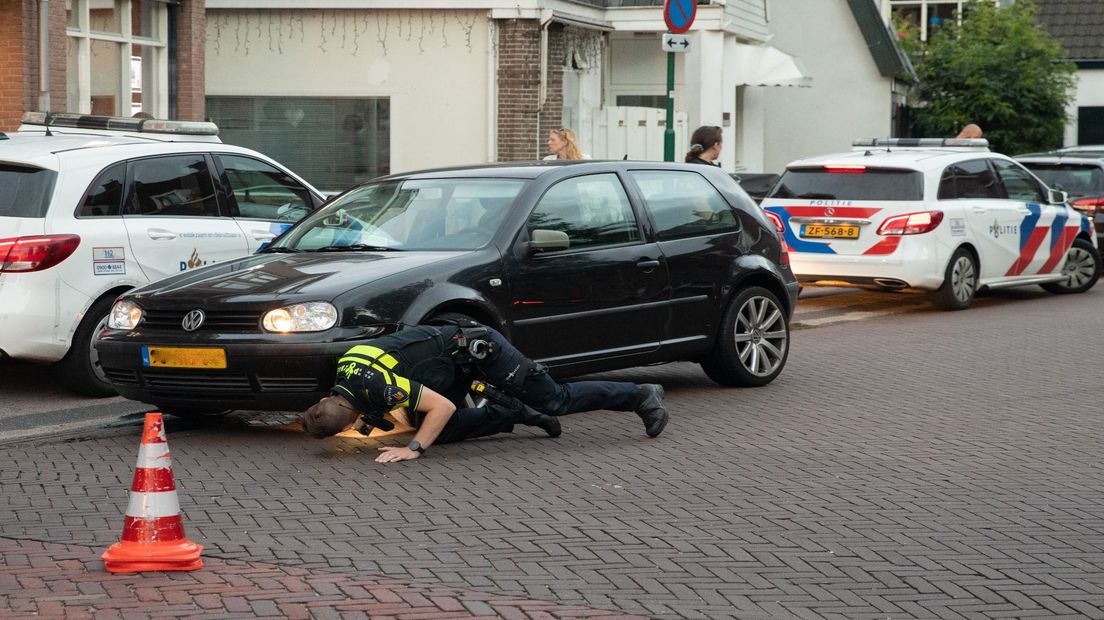 Een agent checkt de klemgereden auto.