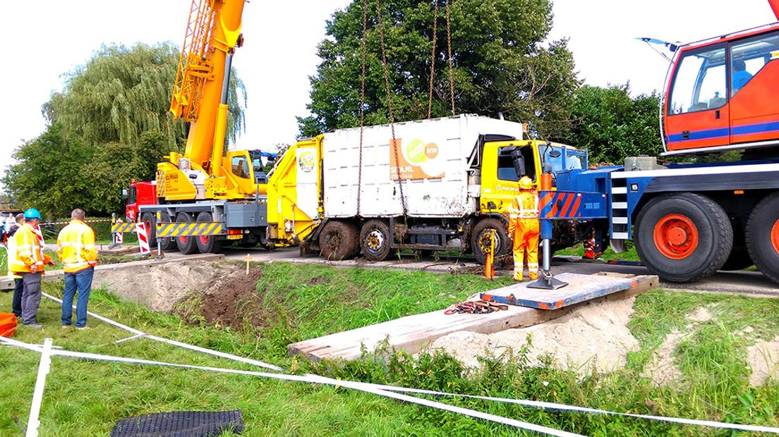 Twee kranen van een kraanbedrijf uit Oosterbeek hebben woensdagmiddag een vuilniswagen uit een sloot in Driel gehaald.