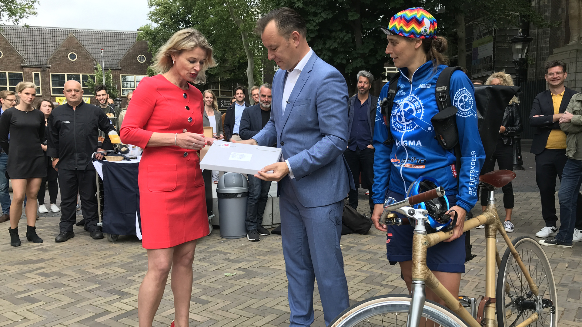 Een fietskoerier brengt het bidbook van het Domplein naar de NPO in Hilversum.