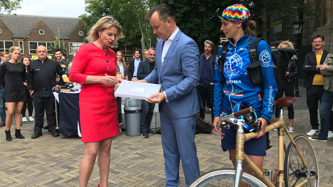 Een fietskoerier brengt het bidbook van het Domplein naar de NPO in Hilversum.