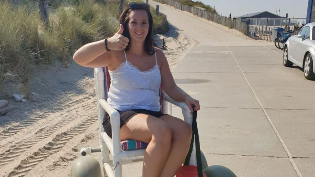 Priscilla op het strand in een rolstoel.