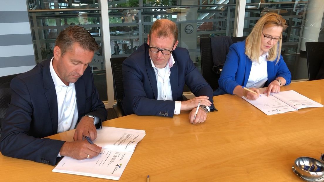 Blije gezichten bij de ondertekening van de stukken