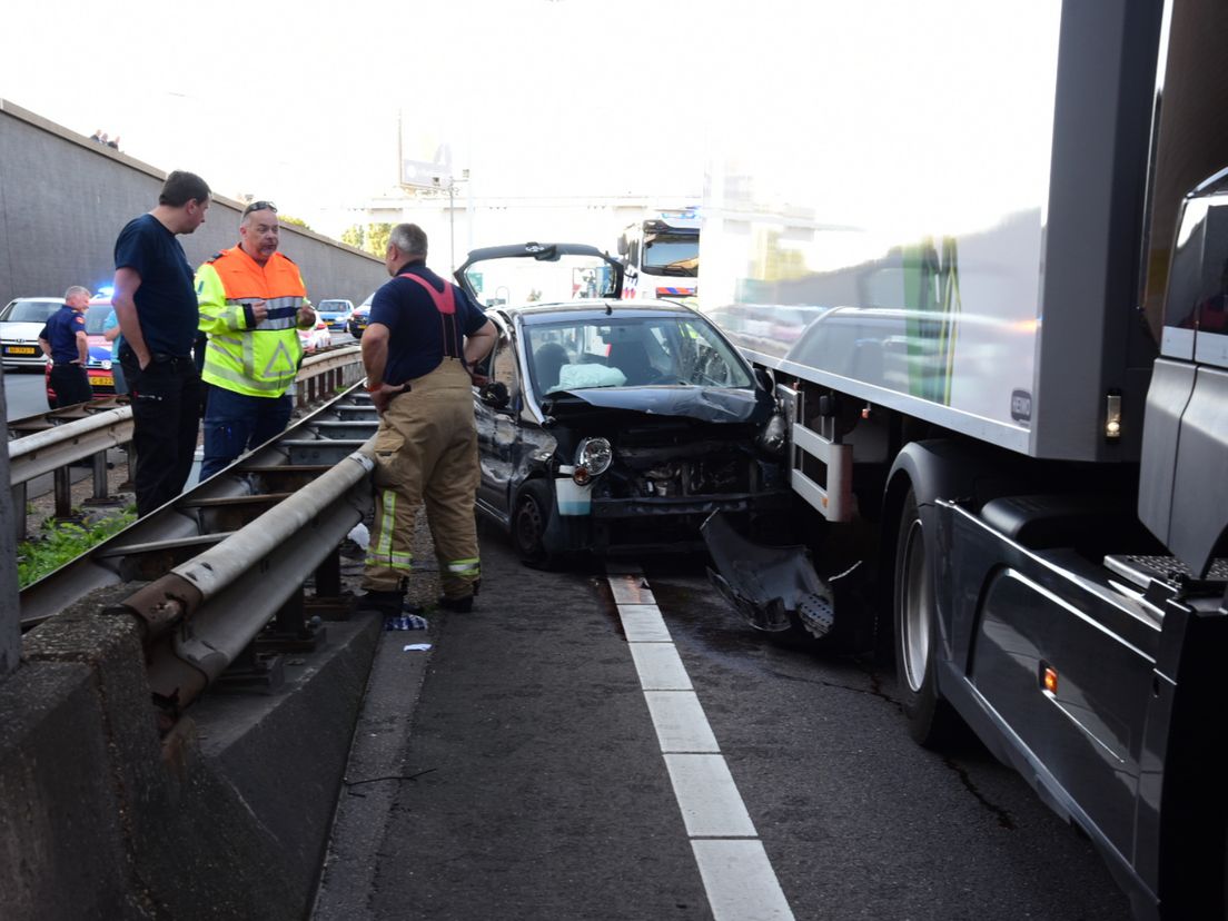 Auto klem tussen vrachtwagen en vangrail