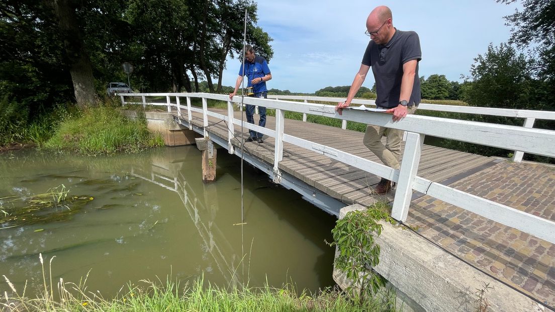 Anko Mertens en Sjoerd Rijpkema van Waterbedrijf Groningen controleren het waterpeil in de Drentsche Aa