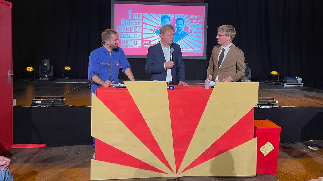 Pieter Omtzigt wordt geflankeerd door presentatoren Wilbert van de Kamp en Bram Douwes