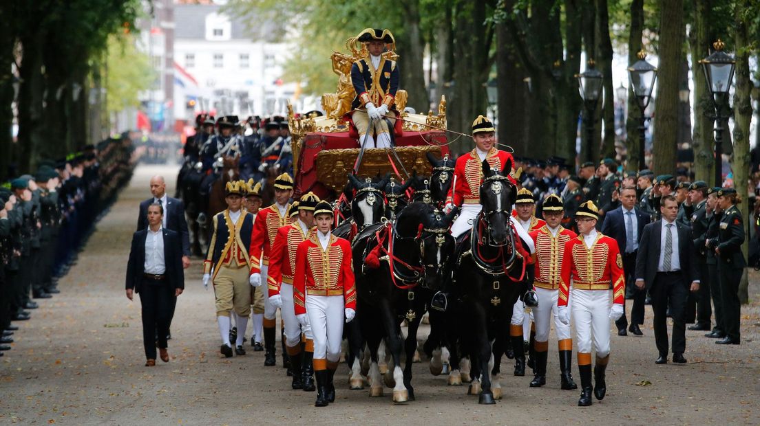 De koning en koningin rijden door het Lange Voorhout