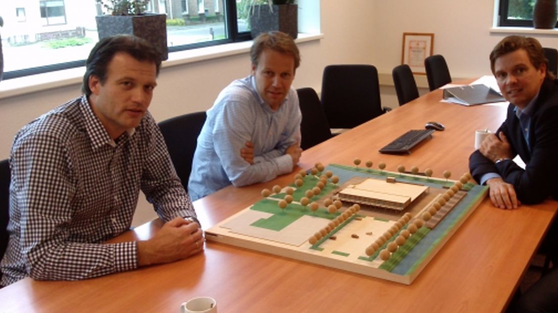 De initiatiefnemers van het nieuwe winkelcentrum met de maquette.