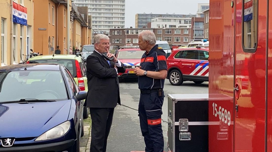 Burgemeester Jan van Zanen laat zich informeren door de hulpverleners op Scheveningen