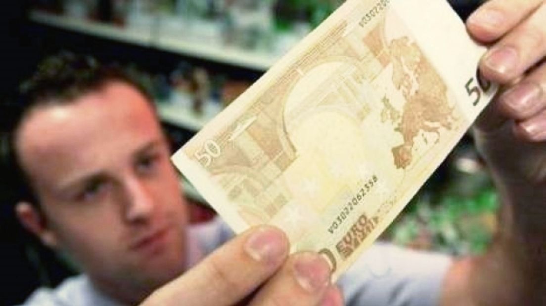 Vals biljet van 50 euro wordt tegen het licht gehouden - archieffoto