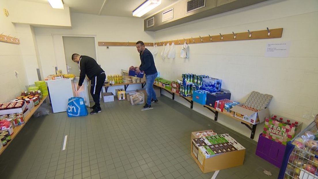 De broers Omar en Mimoun Ahbouk sorteren binnengekomen eten en drinken.