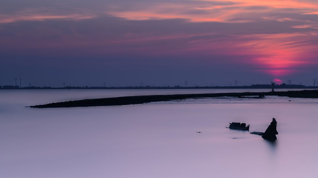 Scheepswrak bij het rondje Amos bij Hansweert bij zonsondergang