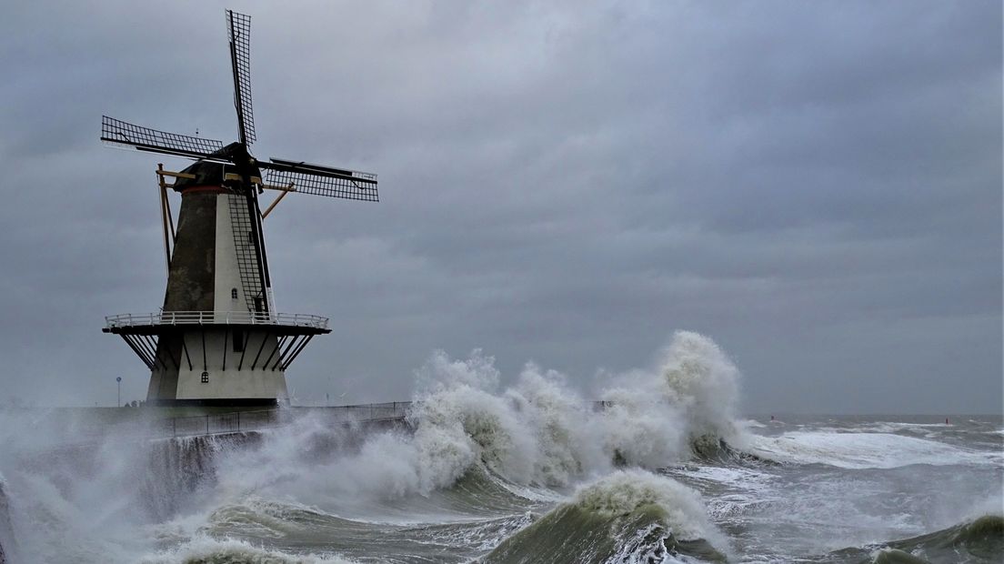 Hoge golven slaan tegen de Oranjemolen in Vlissingen