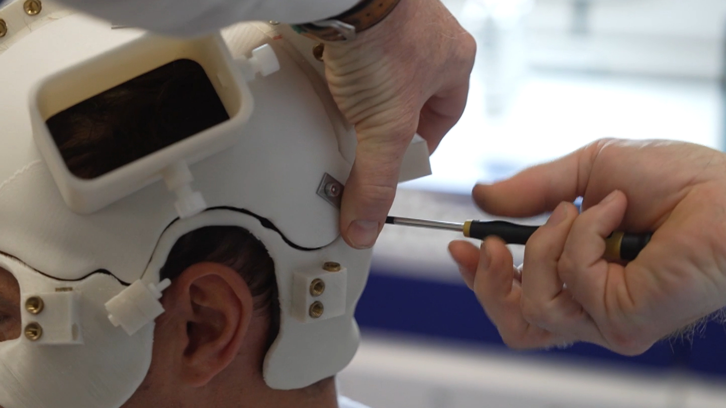 De scanner wordt op het hoofd bevestigd