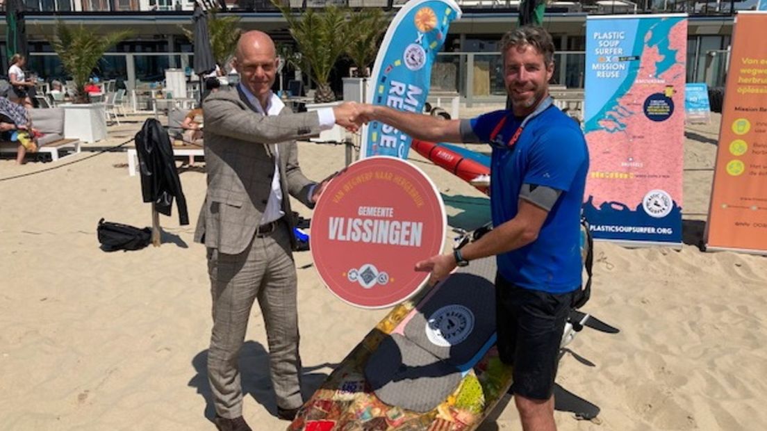 Plastic Soup Surfer Merijn Tinga (r) overhandigt bord aan Vlissingse wethouder Coen Bertijn.jpg