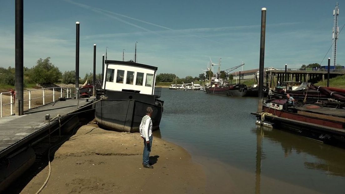 Extreem lage waterstand legt schip in Houthaven op het droge.