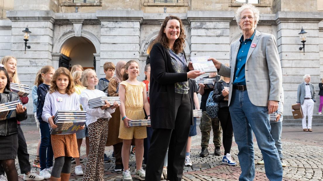 Schrijver Koos Meinderts en 20 Utrechtse basisschoolleerlingen overhandigen 100 exemplaren ‘De Spoken van het Stadhuis’ aan Deirdre Carasso, directeur Bibliotheek Utrecht.