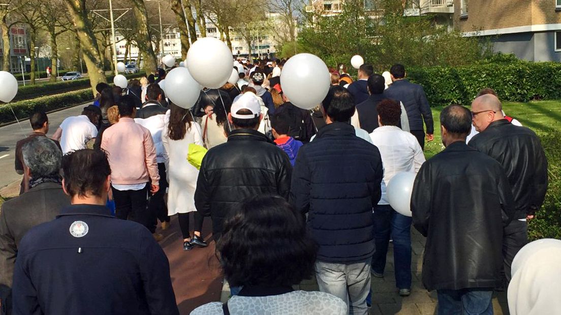 De deelnemers lopen met ballonnen door Den Haag Mariahoeve 