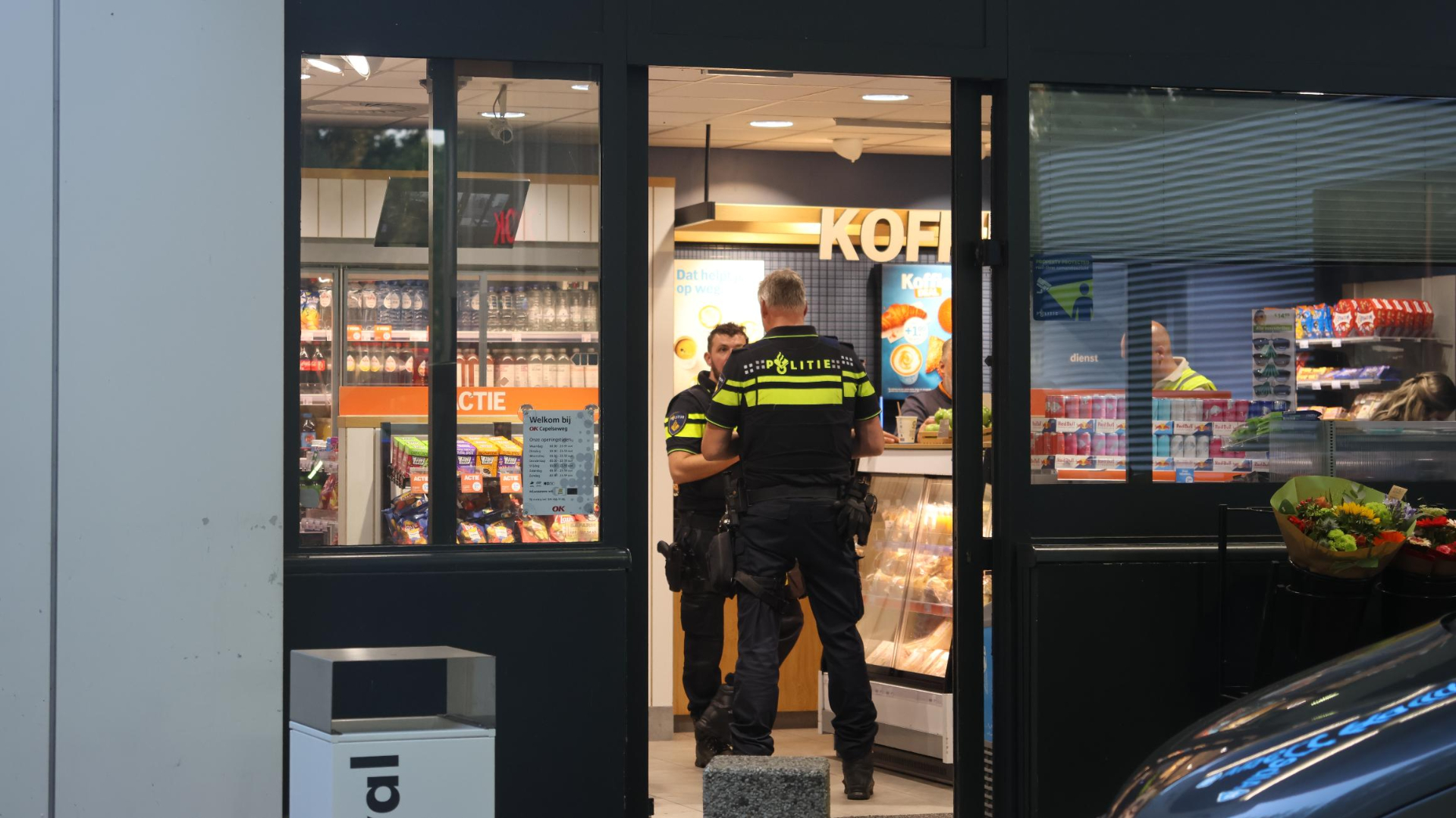 Politieagenten doen onderzoek in het overvallen tankstation