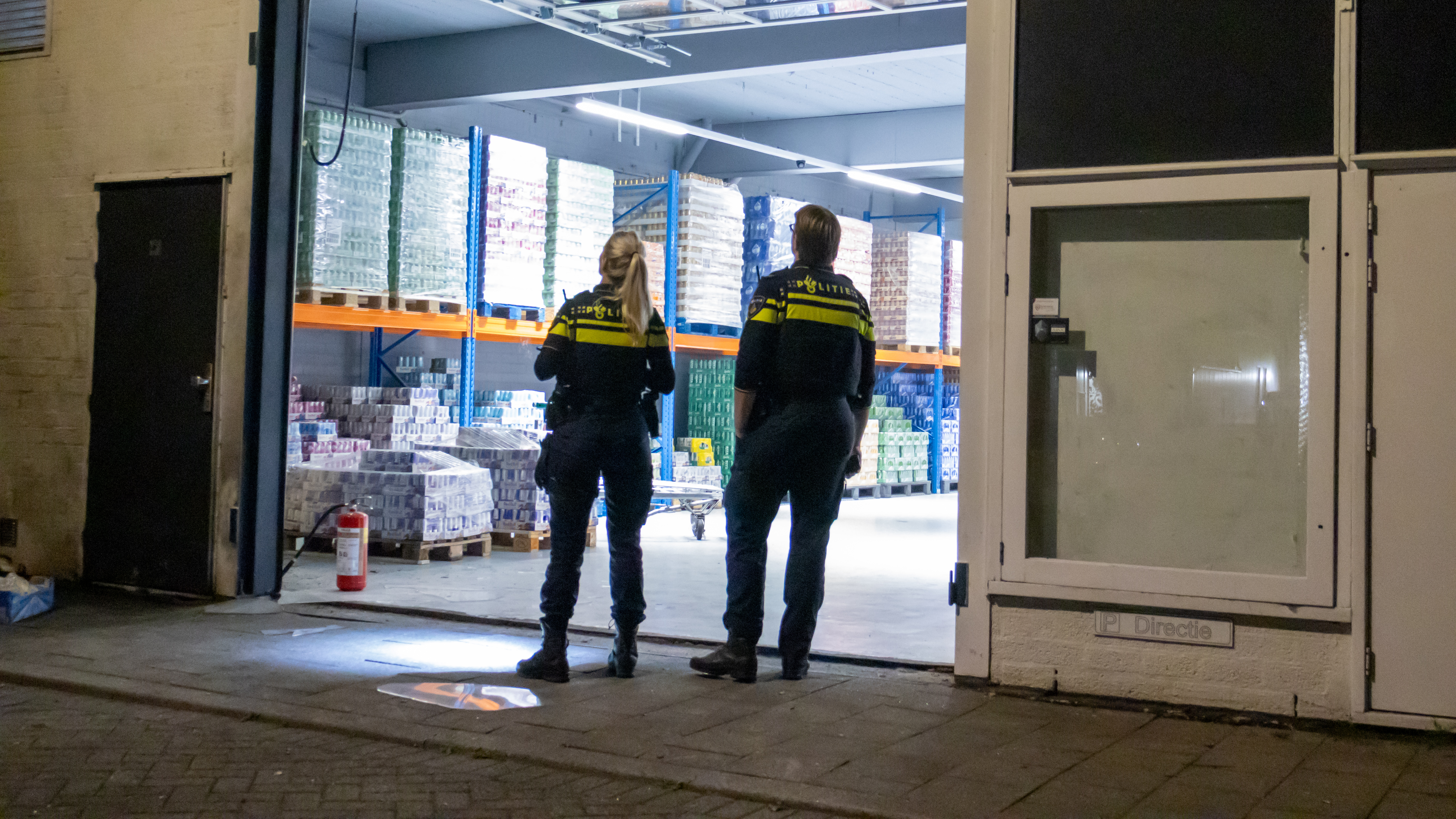 Agenten bekijken de beschadigde roldeur