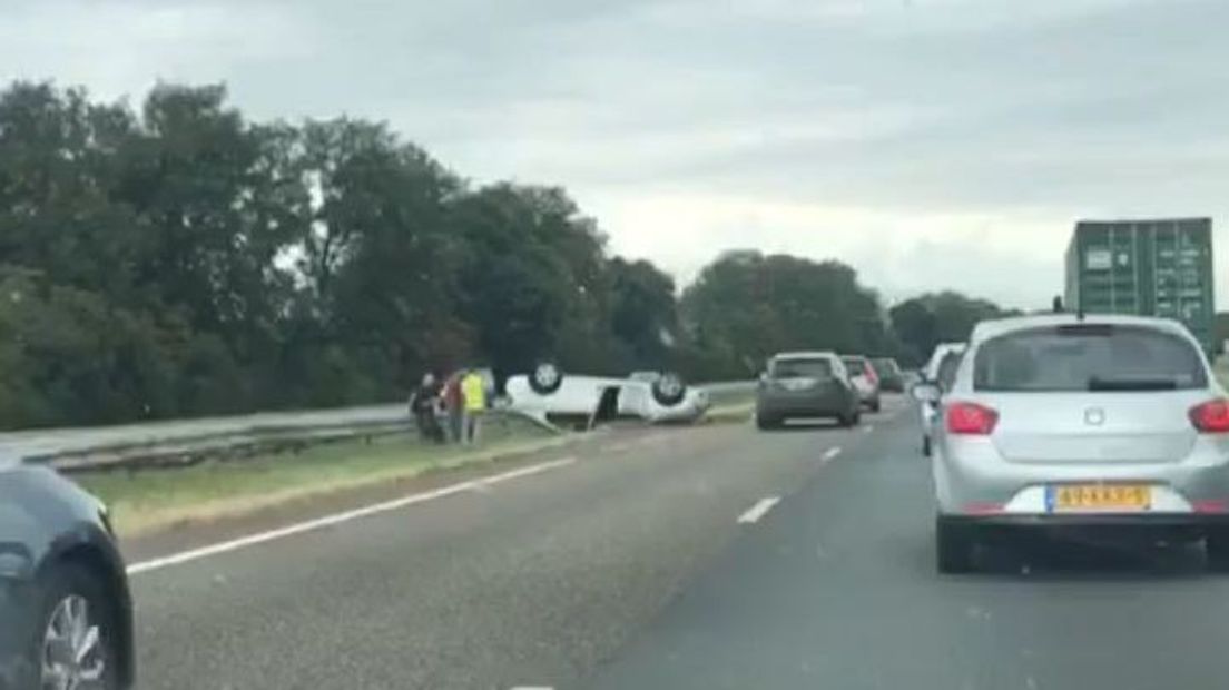 De auto ligt op de kop in de middenberm.