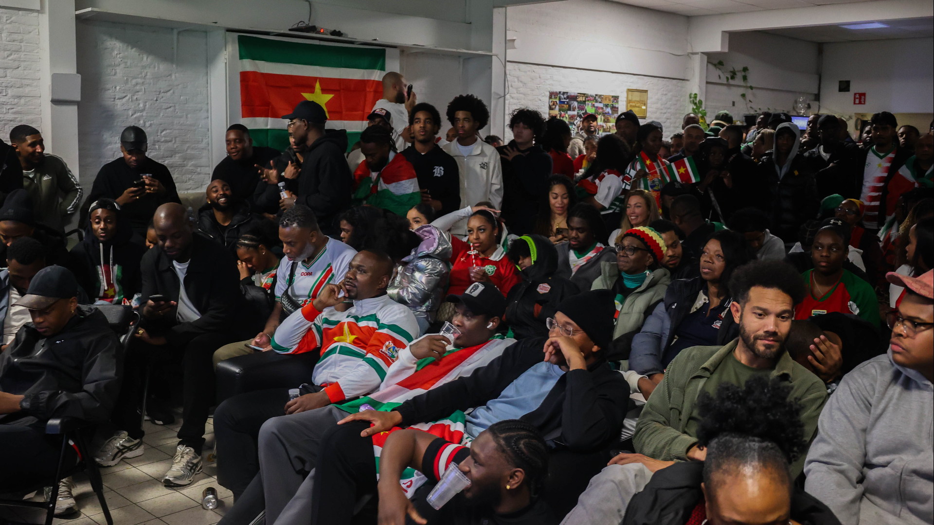 Fans van het Surinaamse elftal kijken bij voetbalvereniging Zwarte Pijl
