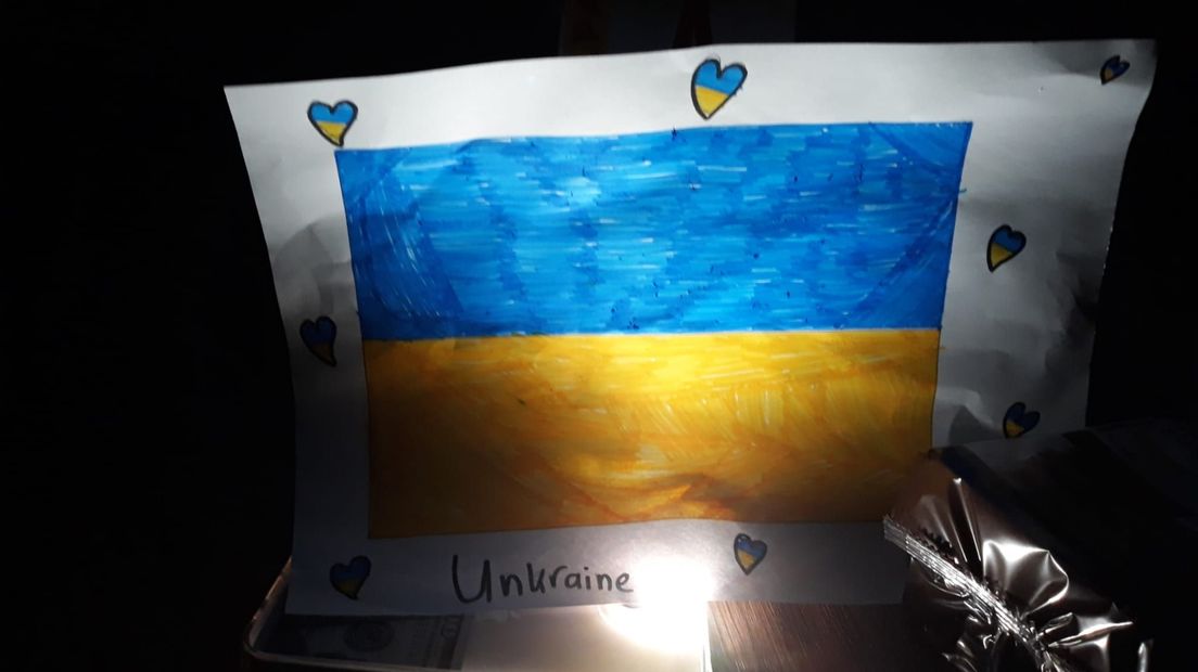 Een tekening van de Oekraïense vlag, tijdens de stroomstoring verlicht door een mobieltje