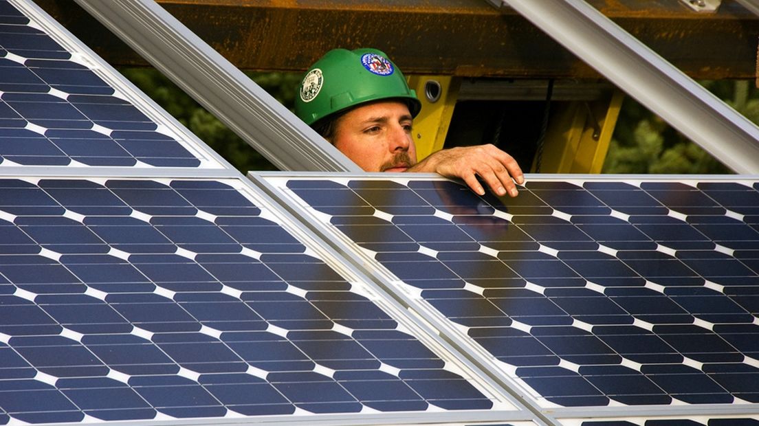Een installateur monteert zonnepanelen