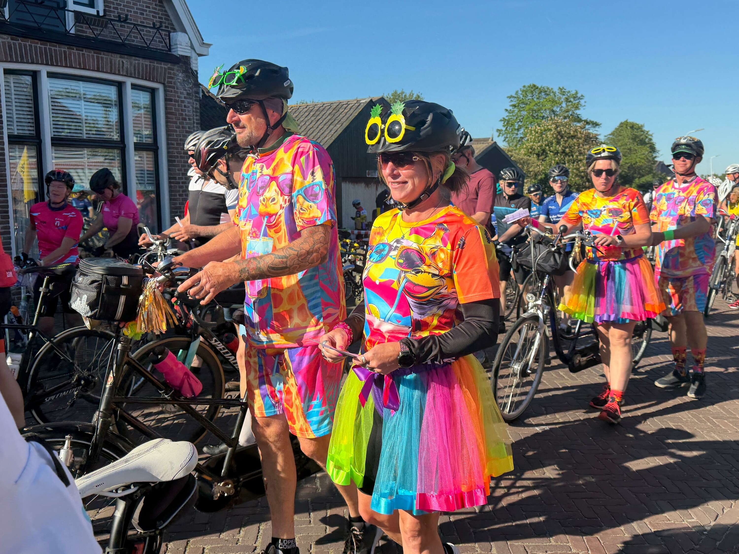 Fietsers in mooie kledij in Holwert, met een volledig blauwe lucht op de achtergrond