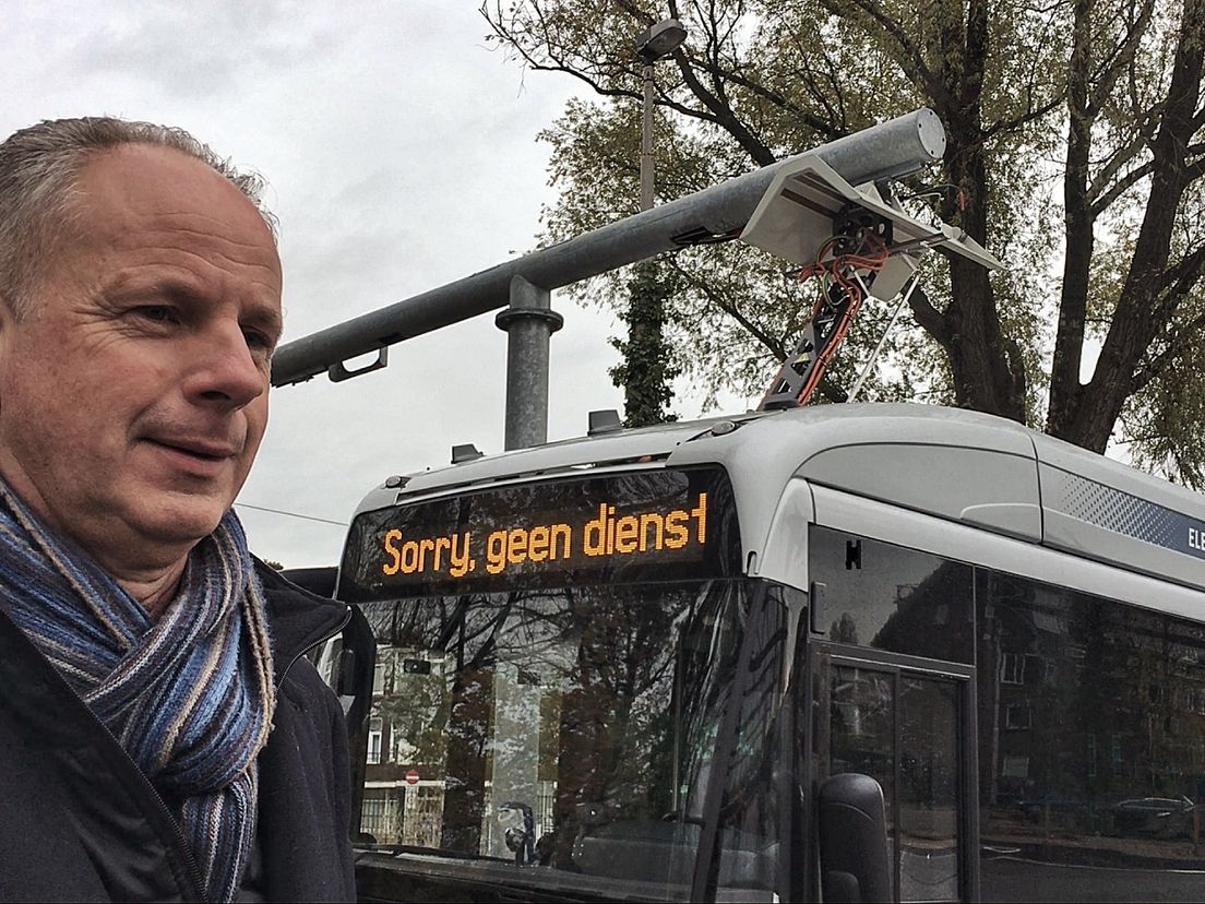 Johan Taal van de RET voor een bus die via de pantograaf oplaadt