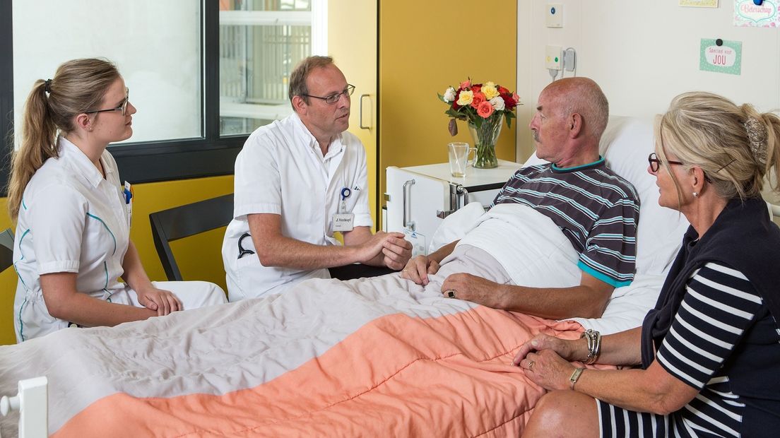 Verkuyl (tweede van links) aan het bed van een patiënt (niet Rozendal)