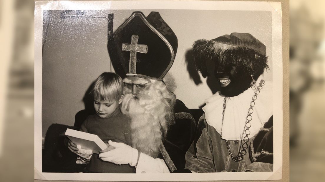 Sint en Piet pakken samen met een kind een cadeautje uit