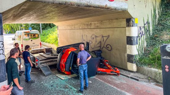 Graafmachine valt van aanhanger na botsing tegen viaduct. Graafmachine valt van aanhanger na botsing tegen viaduct.
