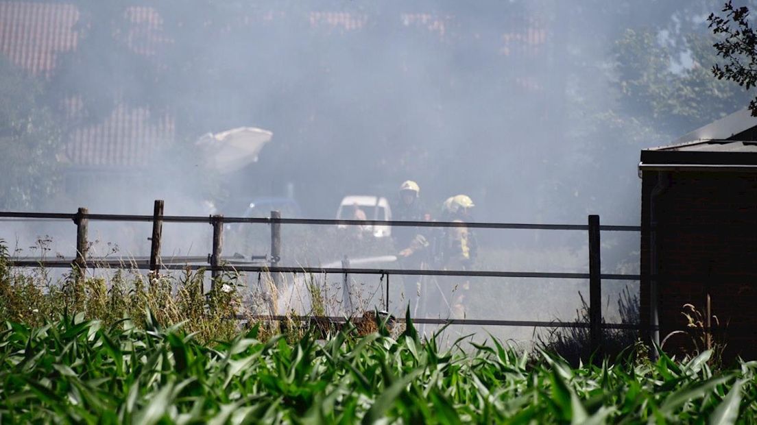 Brandweer blust brand in weiland met paarden in Geesteren