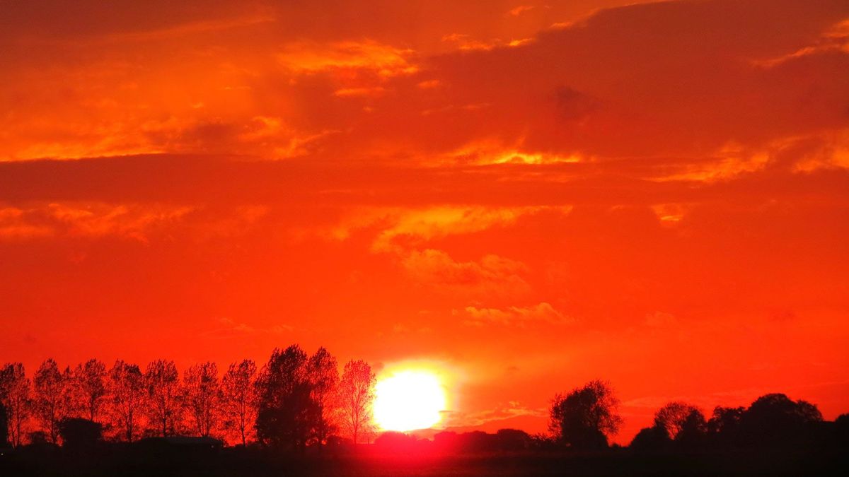 Zonsondergang kleurt lucht boven Groningen vuurrood