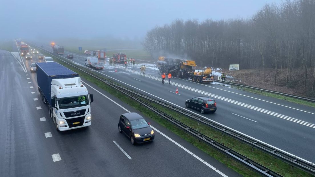 Verkeer op de A7 rijdt weer, op de achtergrond de uitgebrande kraanwagen