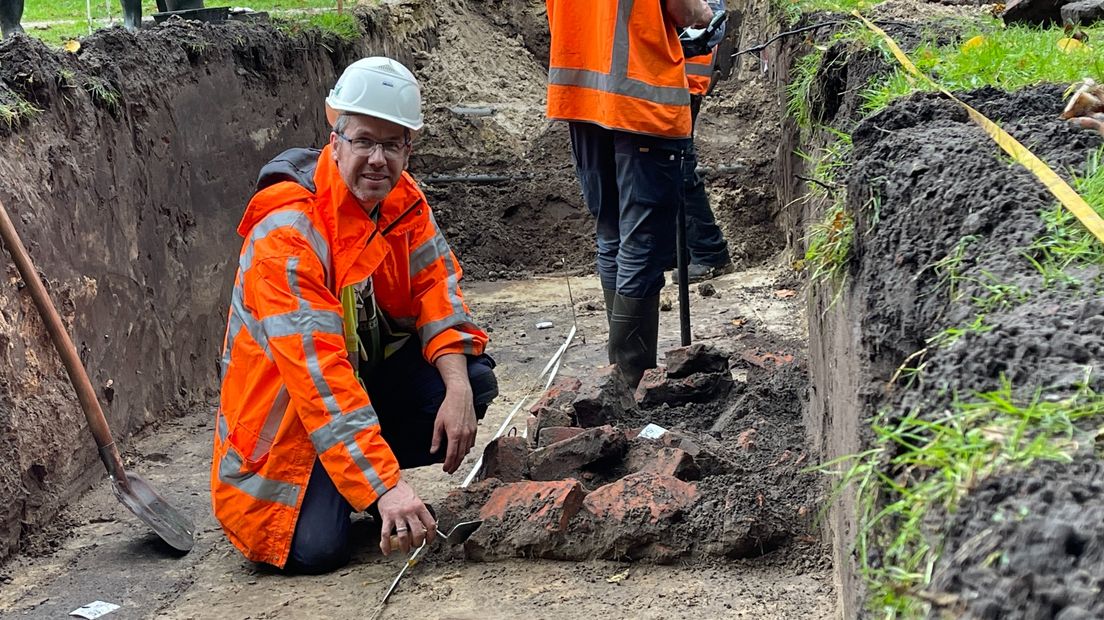 Archeoloog Stijn Arnoldussen bij de stenen die onder de grond verstopt zaten