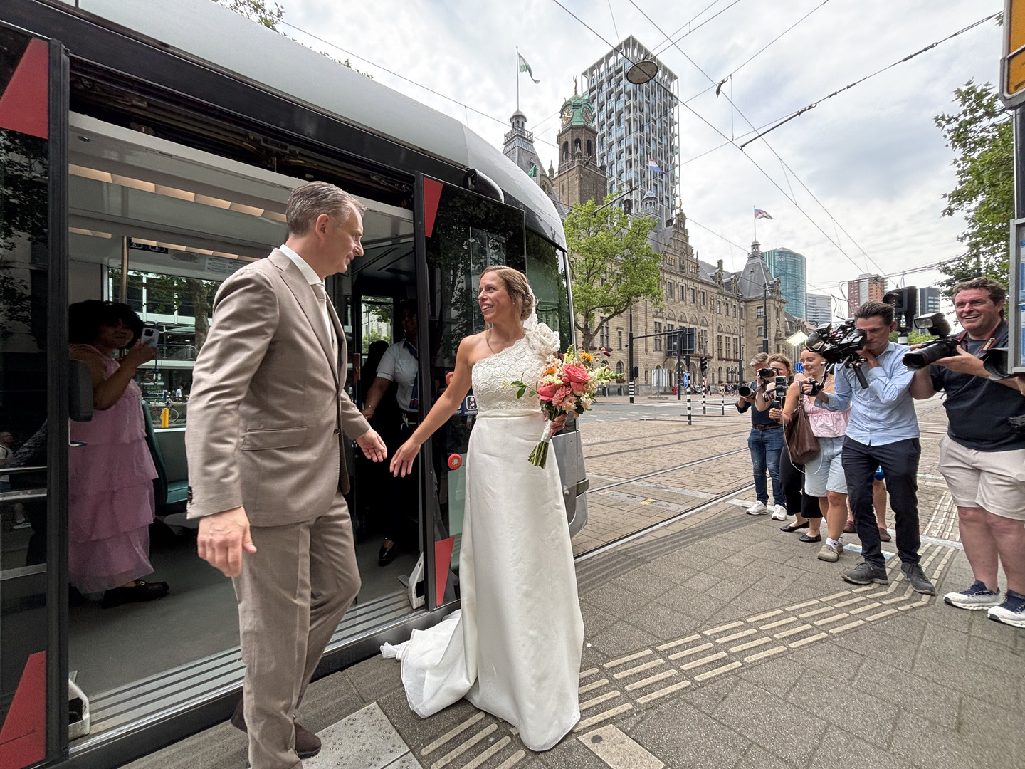 Burgemeester Schouten en bruidegom Coert Kleijwegt stappen uit de tram bij het Stadhuis.
