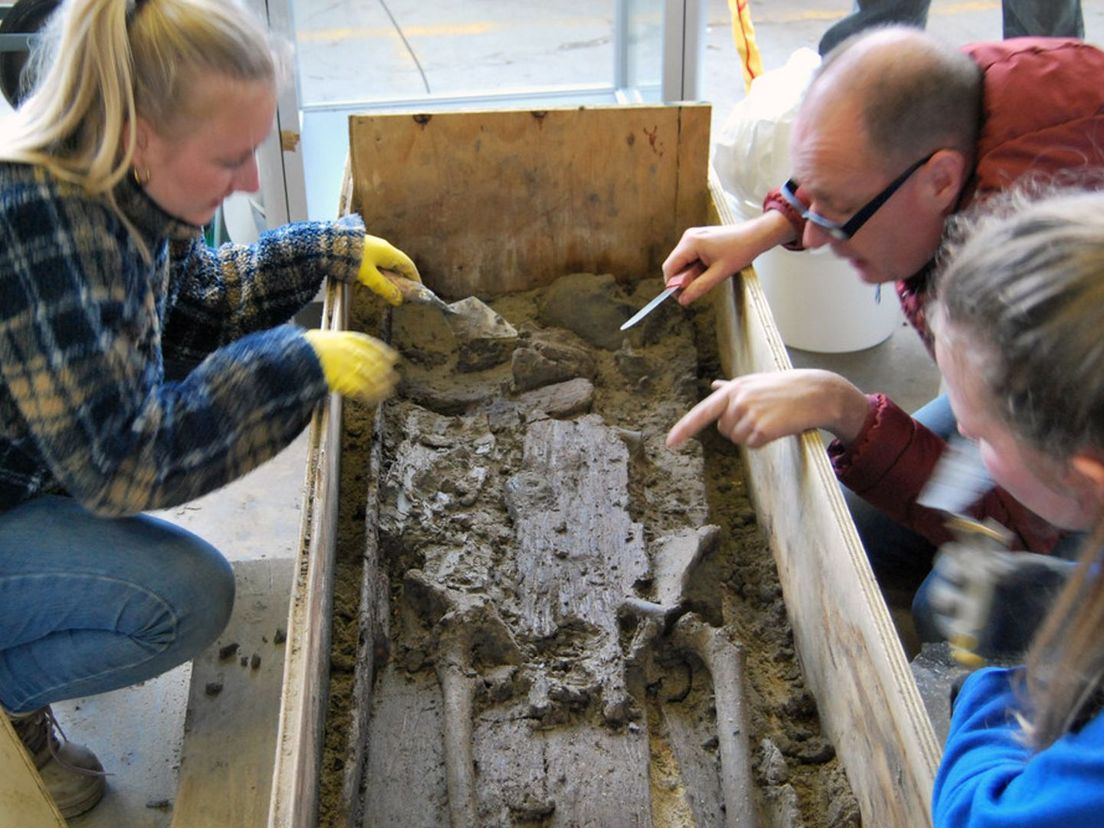 Vita Schouten (links) en Jeroen Ras (rechts) doen onderzoek naar het skelet van de vrouw.