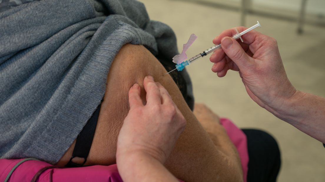 bovenarm met injectienaald coronavaccin