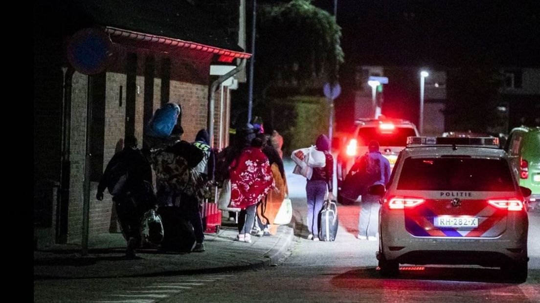 Politie begeleidt de Roemenen naar een hotel.