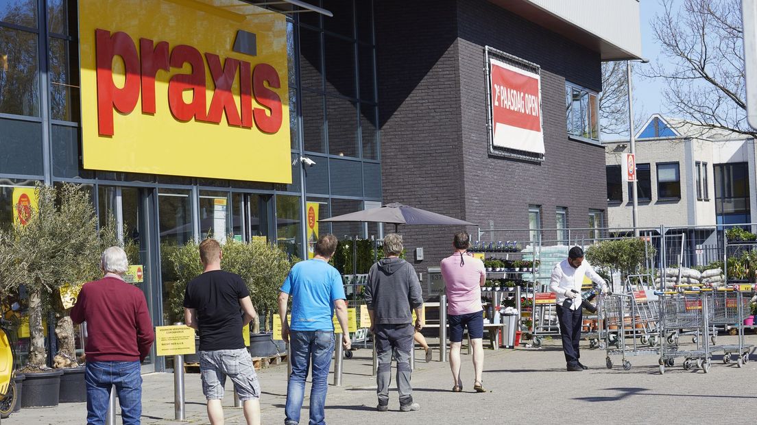 Een vertrouwd beeld tijdens corona: mensen bij de bouwmarkt bewaren buiten anderhalve meter afstand.