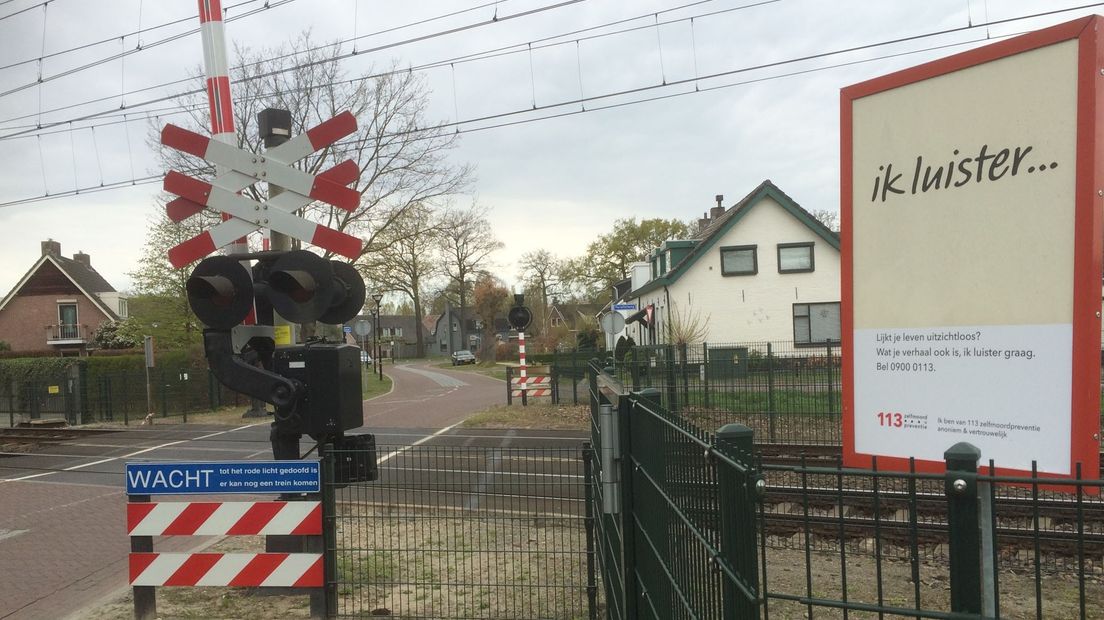 Een bord van de zelfmoordpreventielijn langs een spoorbaan