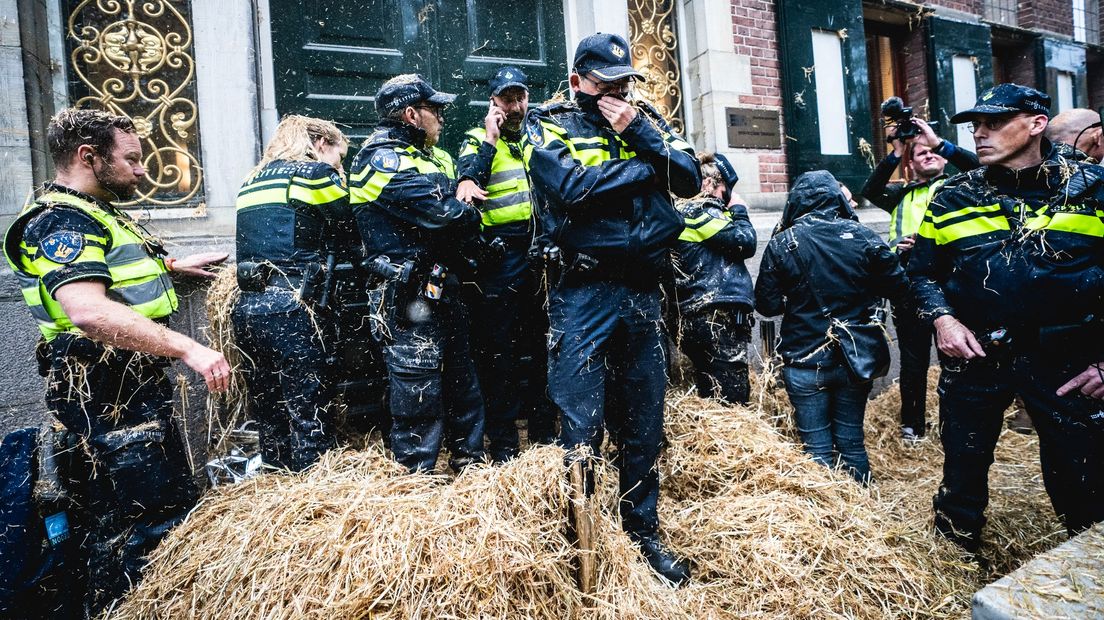 Politieagenten worden belaagd met stro tijdens het boerenprotest voor het provinciehuis in Groningen.