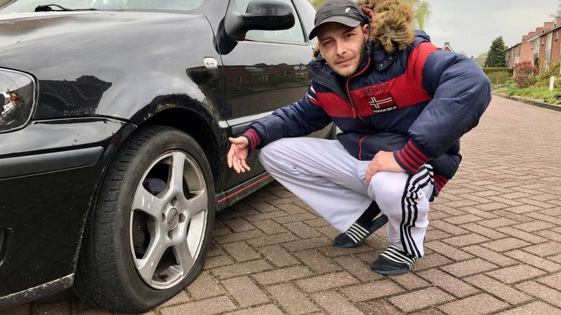 Joey Meijer bij zijn auto met lekke banden