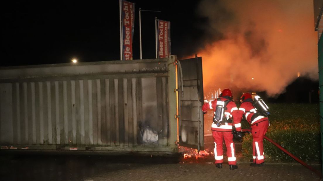 Twee brandweerlieden zijn bezig met blussen